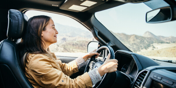 Woman driving through mountain range